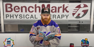 Knoxville Ice Bears hockey player reading in front of the penalty box