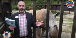 Director of Zoo Knoxville reading to a rhinoceros
