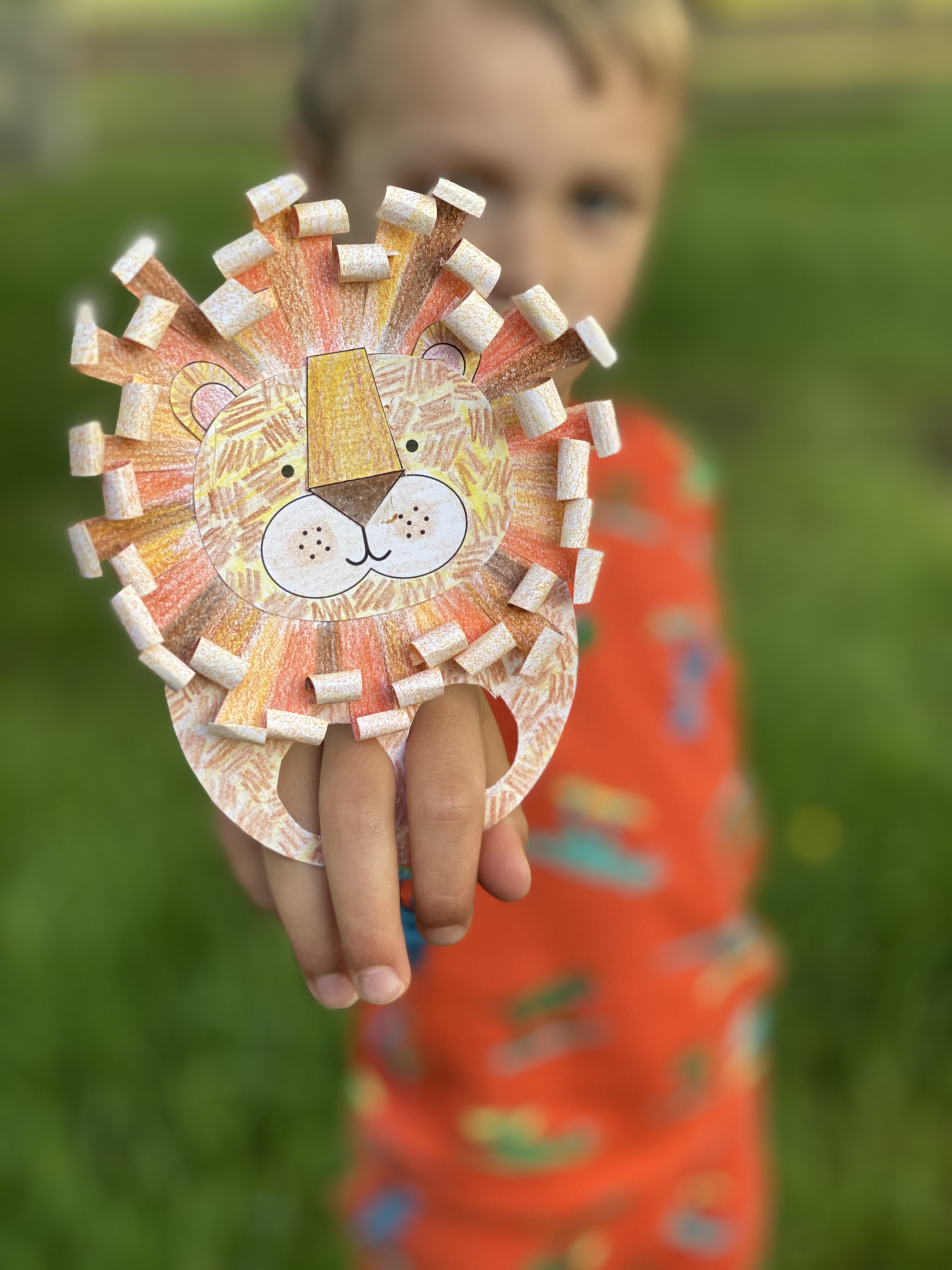 Young boy holding up his finished lion finger puppet