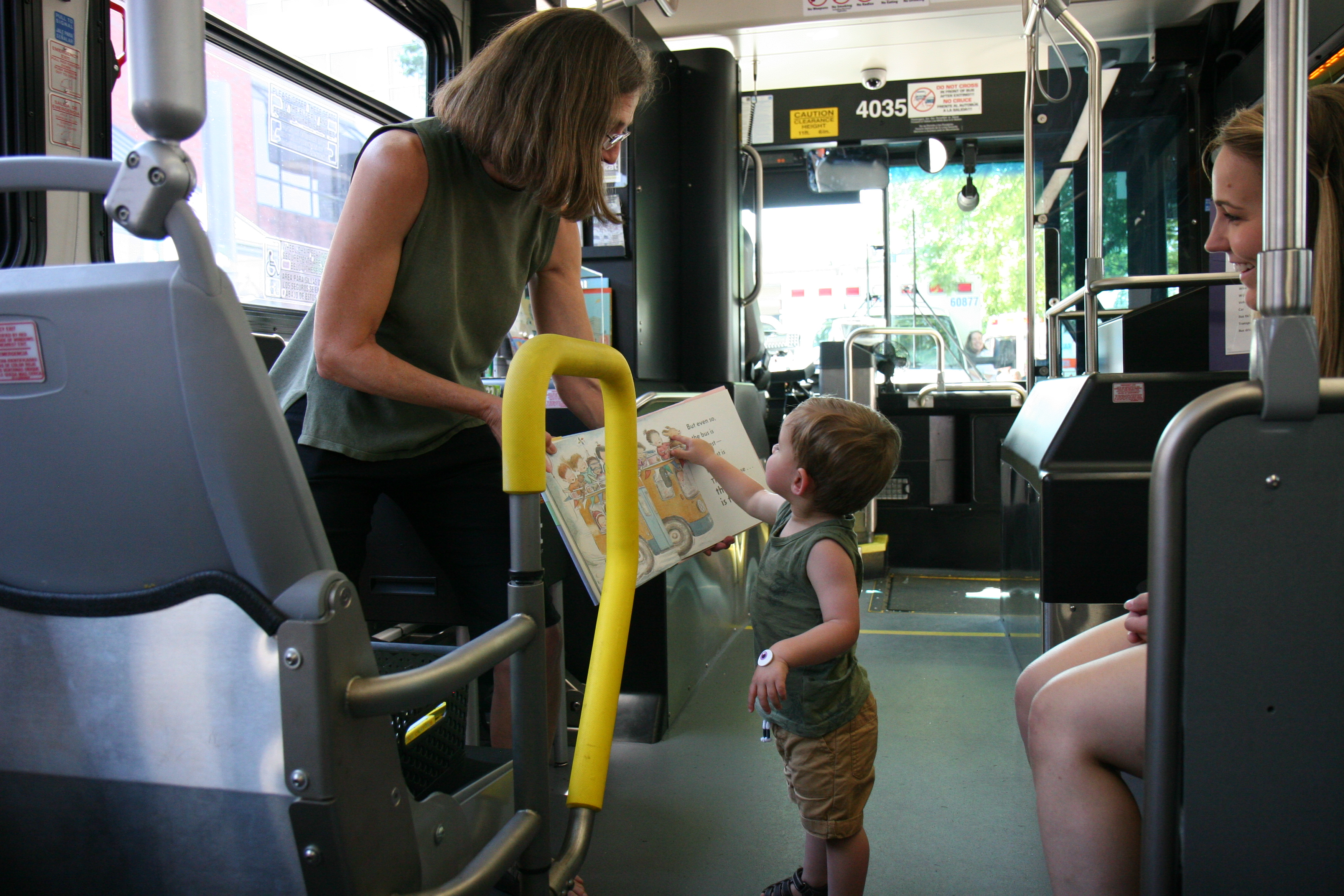 Toddler pointing at storybook in bus en route to festival