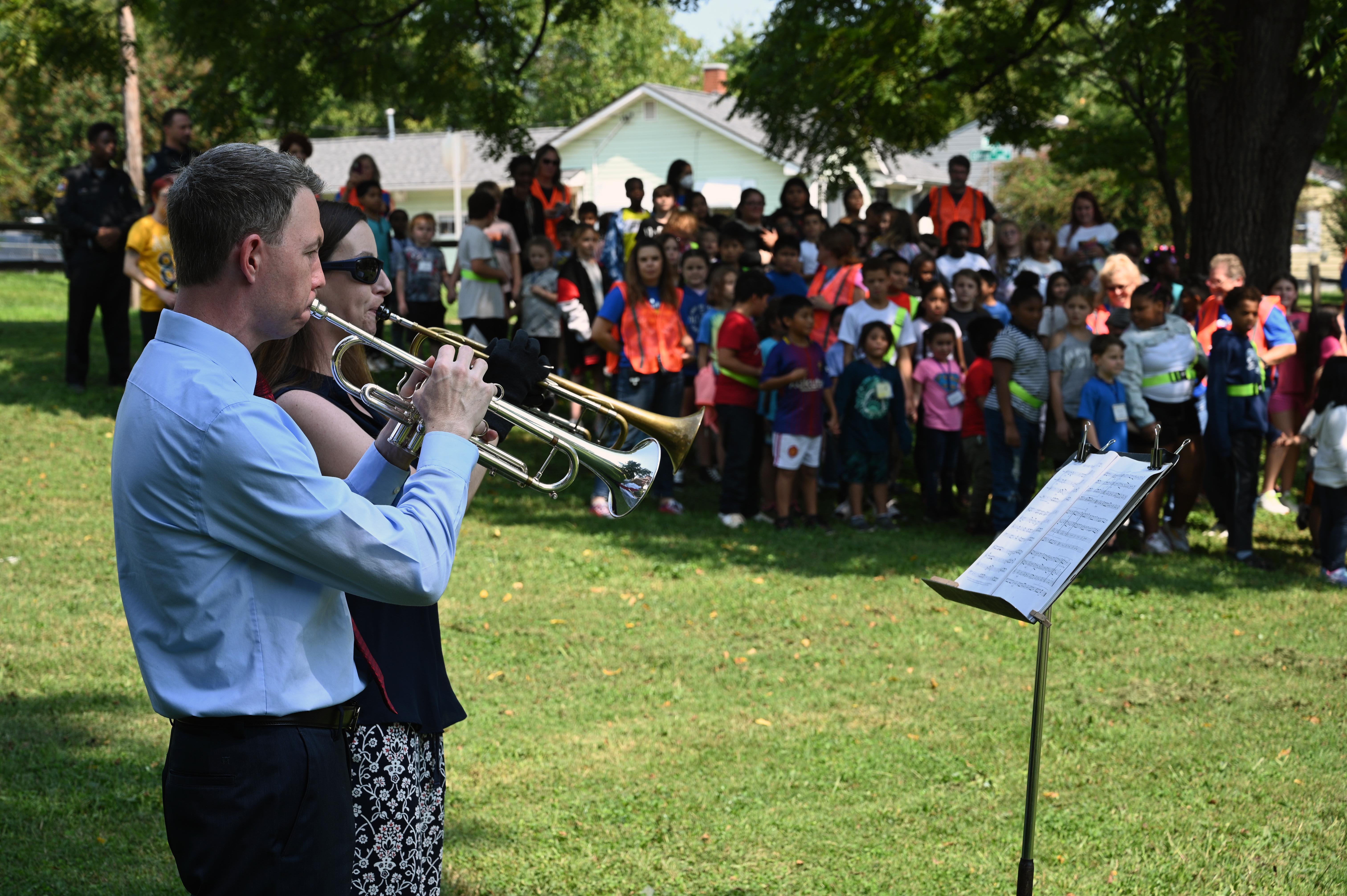 two trumpet players play for elementary students