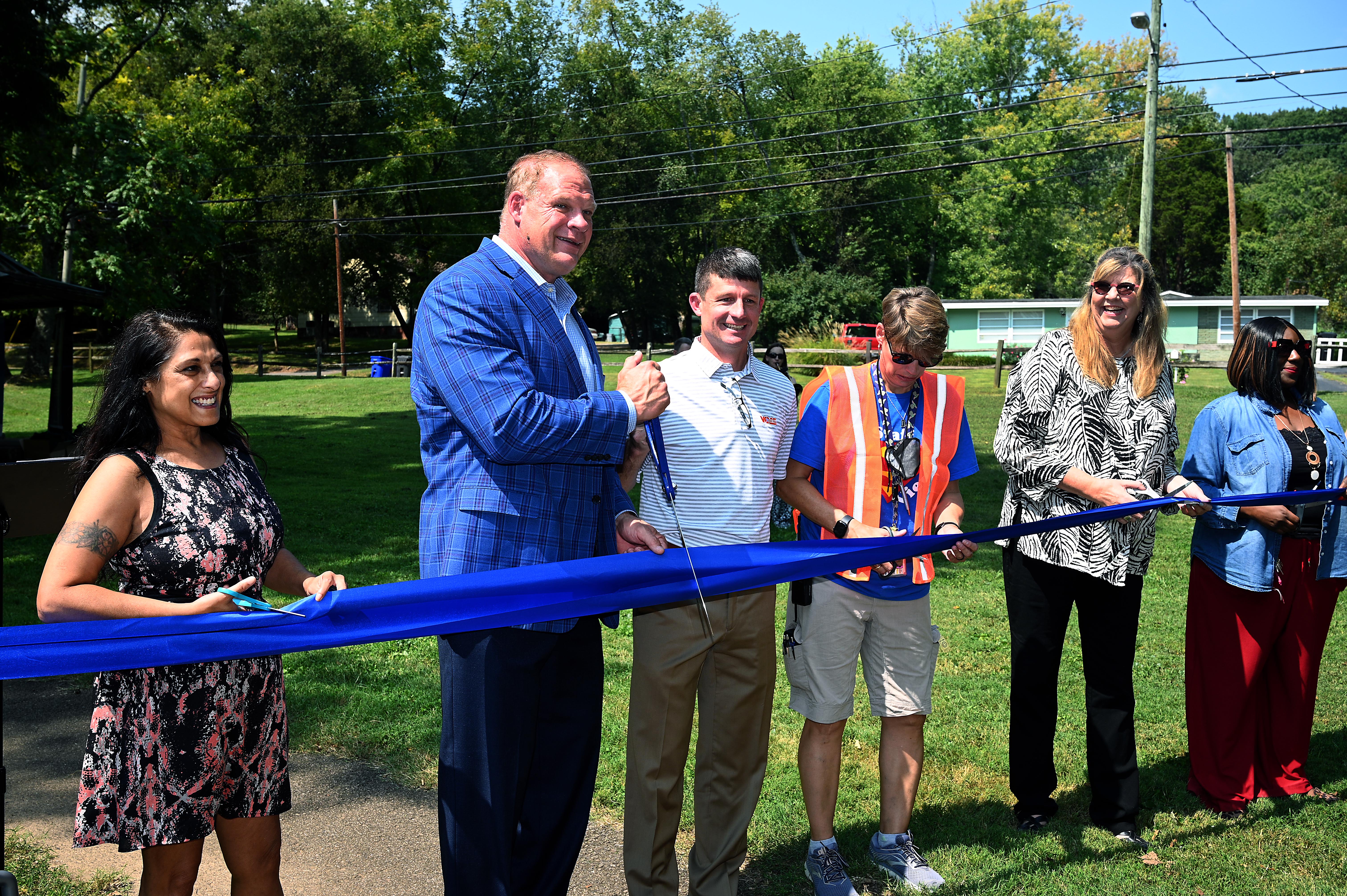 Mayor Glenn Jacobs and others cut a large blue ribbon