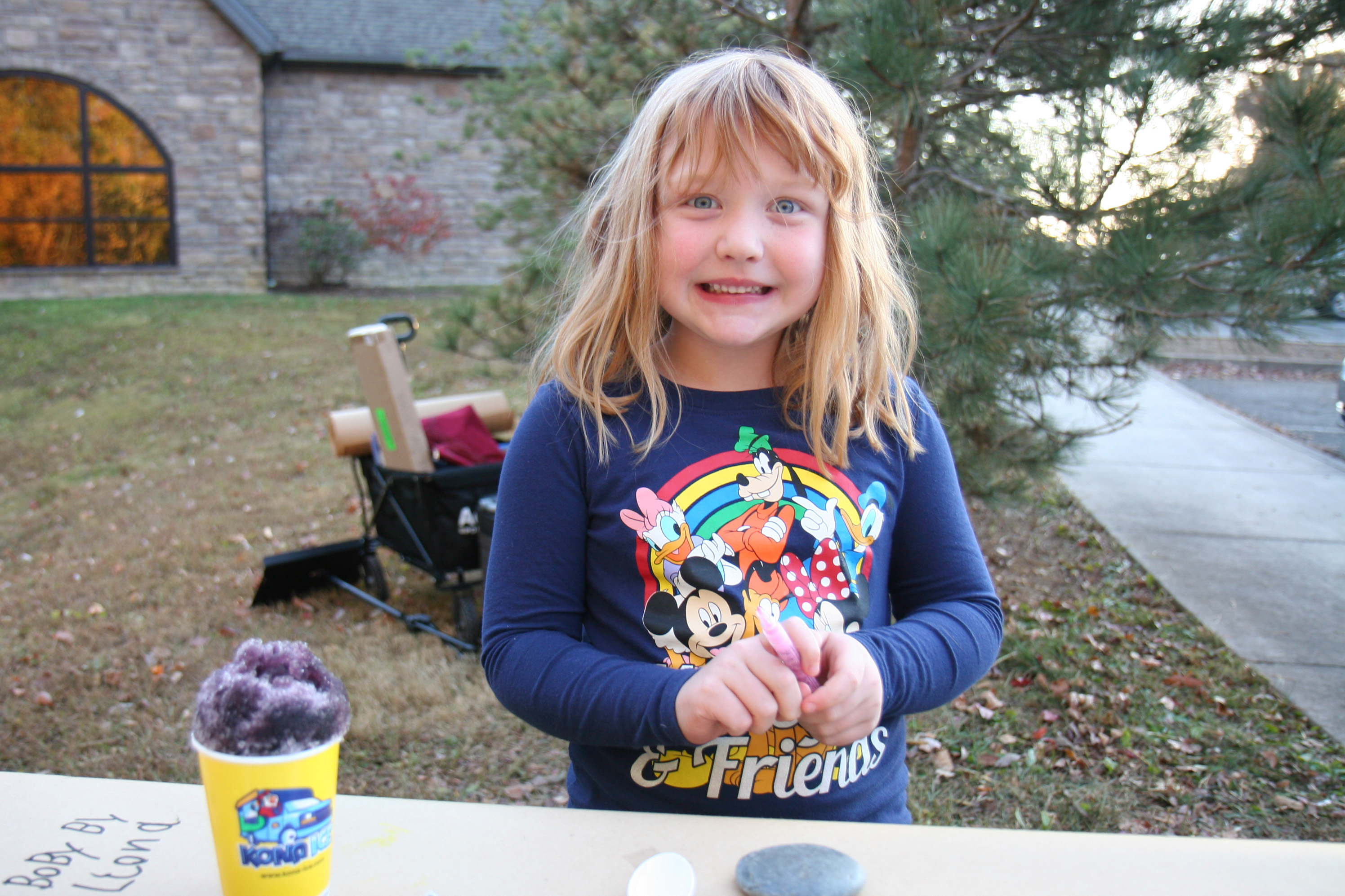 young girl smiles and gets ready to paint a rock