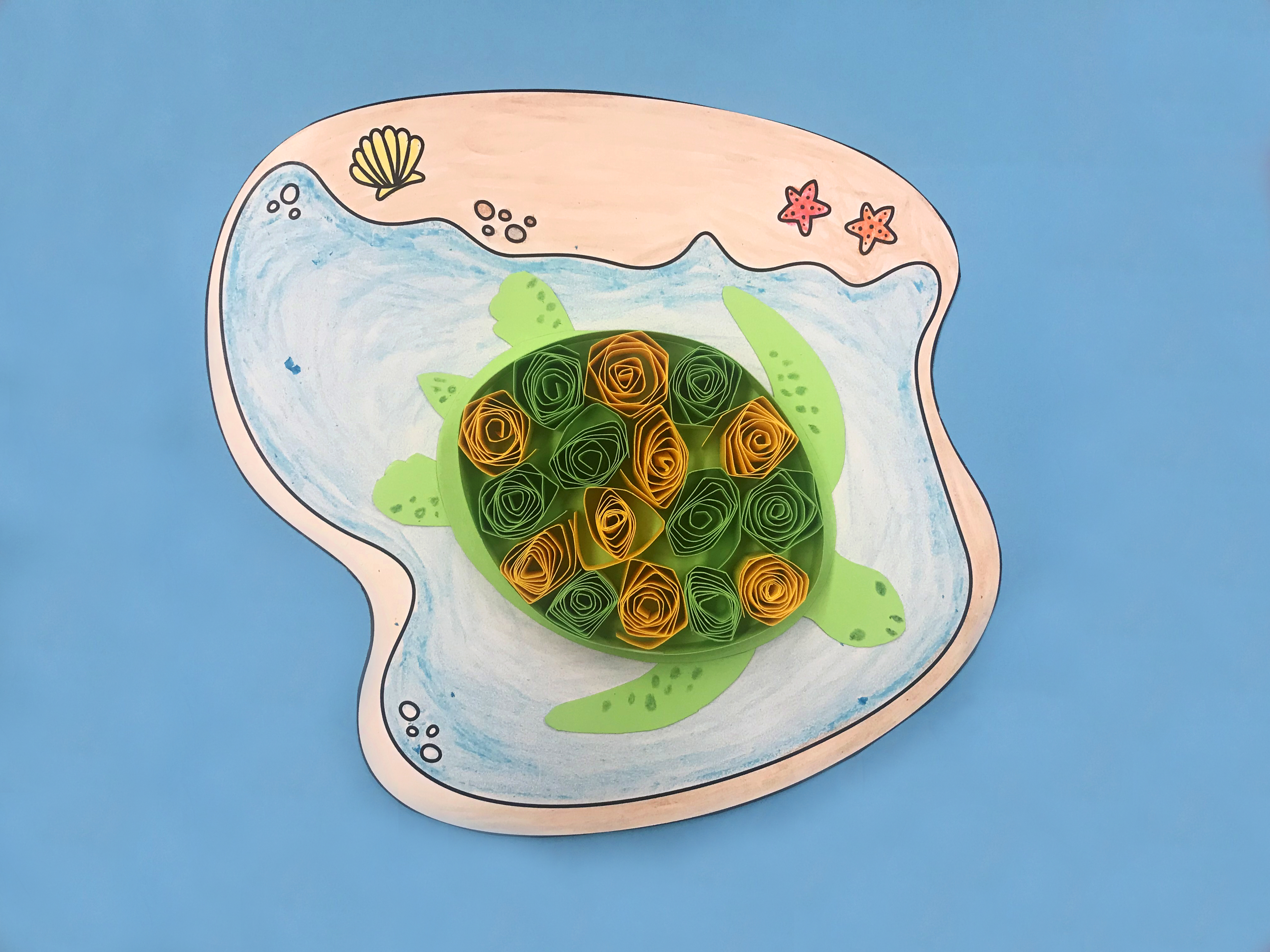 photo of a paper turtle with shell made of small rolls of green and yellow paper