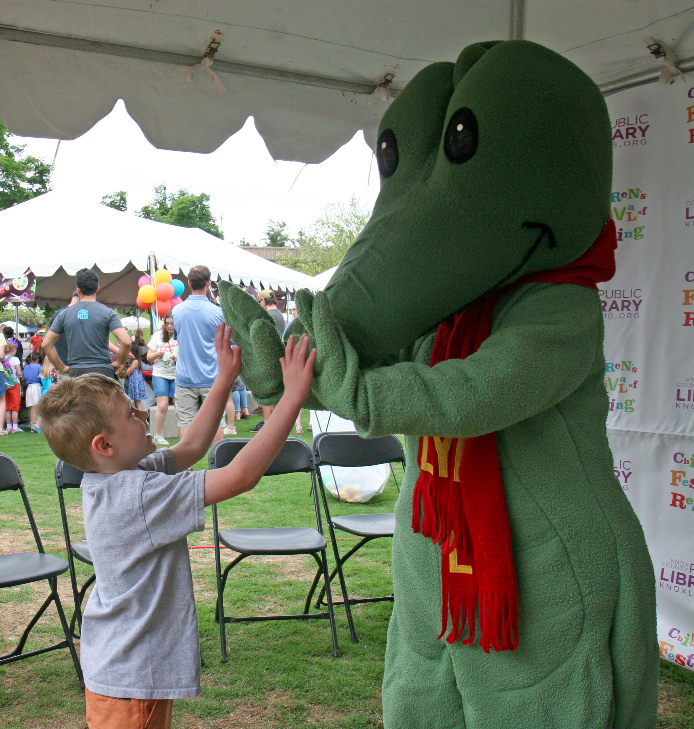 Boy high-fives Lyle Crocodile costume character
