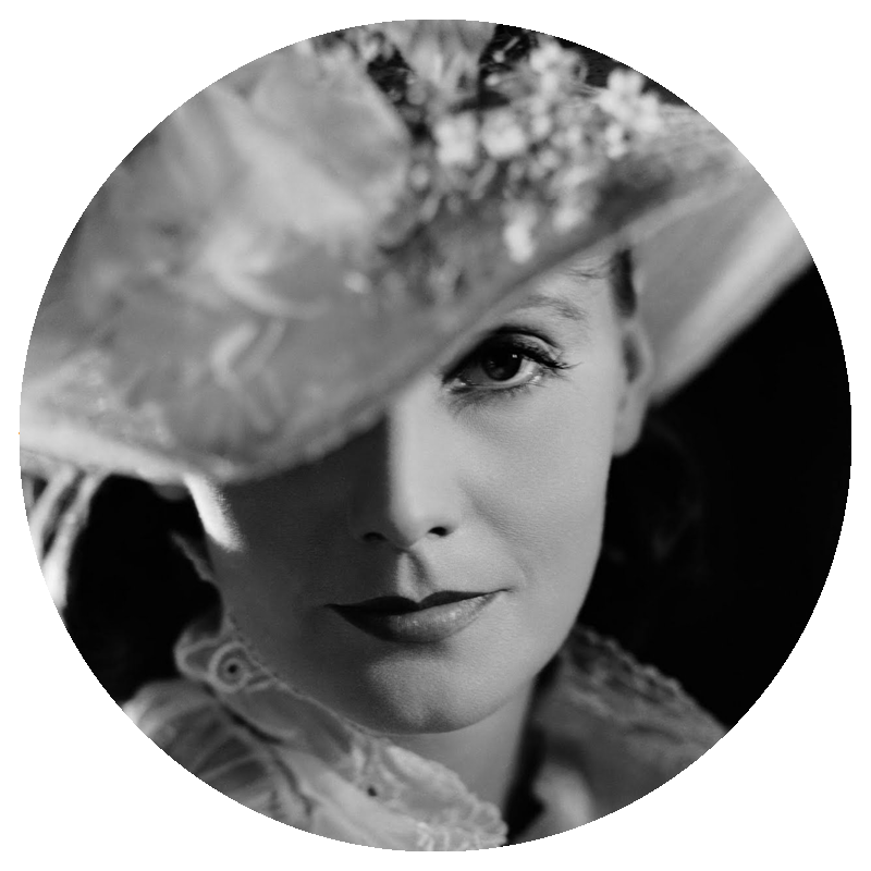 photo of Greta Garbo looking directly at camera in a large hat, brim covers one eye