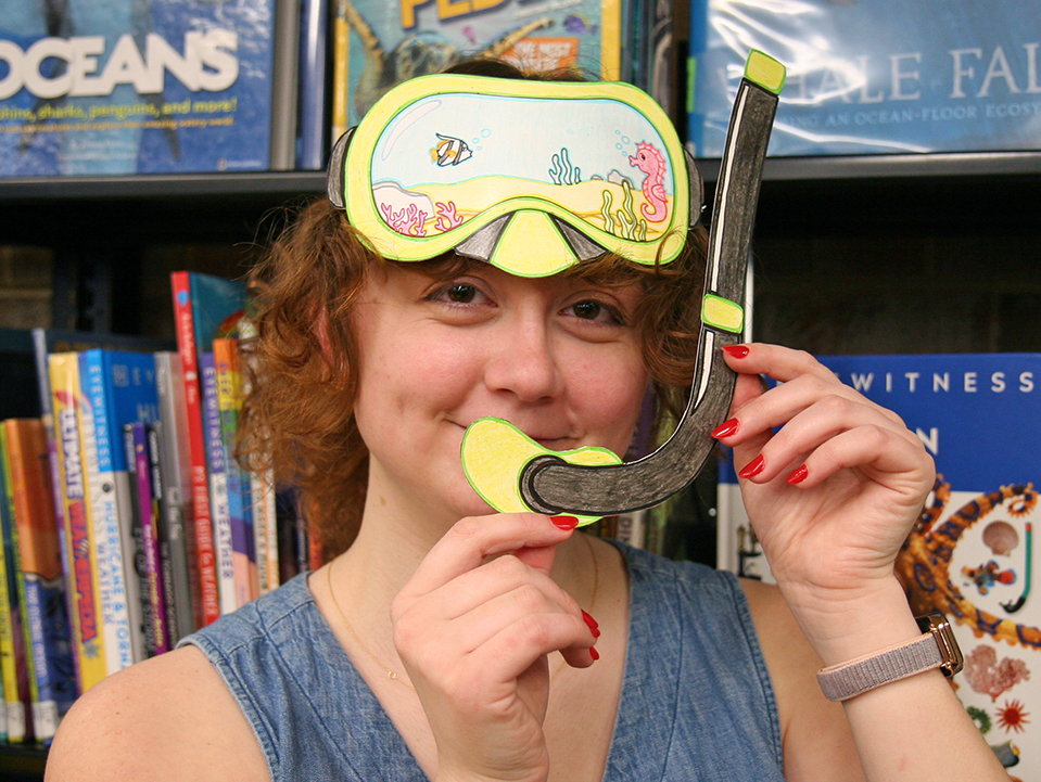 young woman wearing colored paper diving mask and snorkel