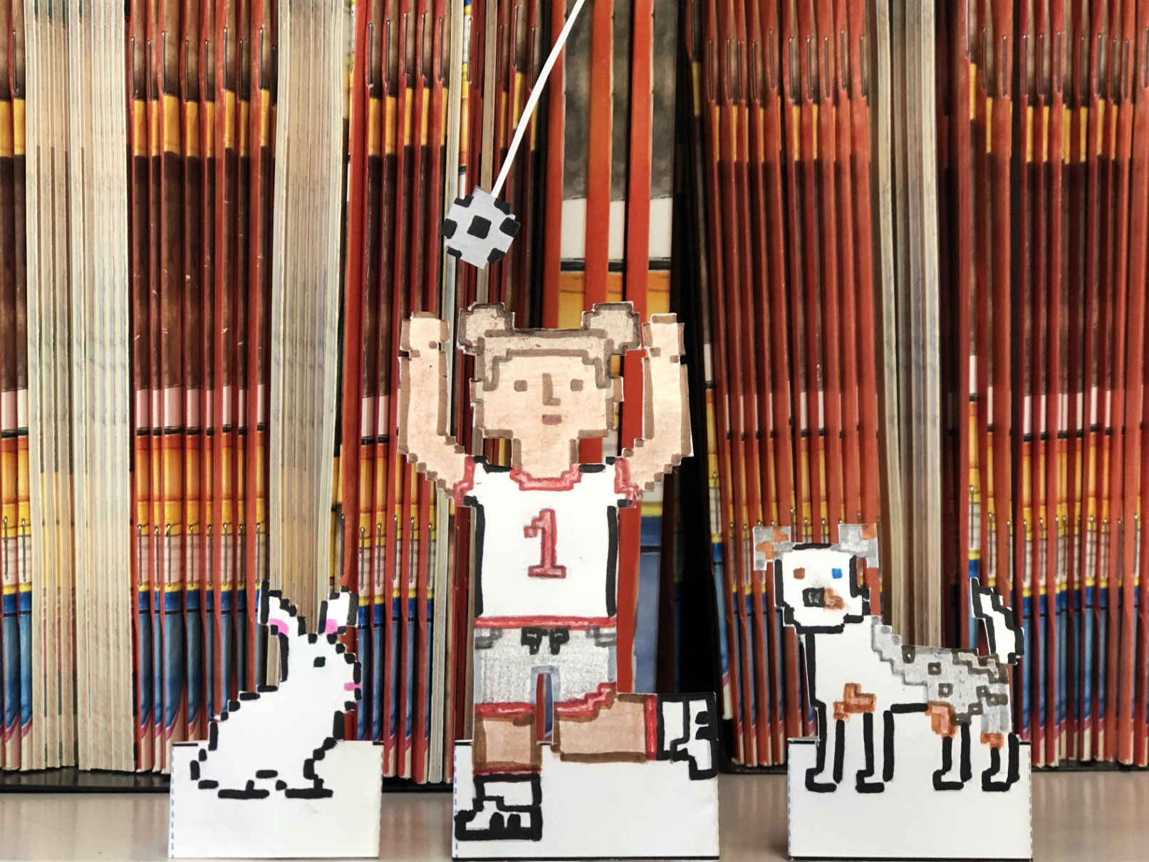 paper craft of girl playing soccer with a dog and rabbit
