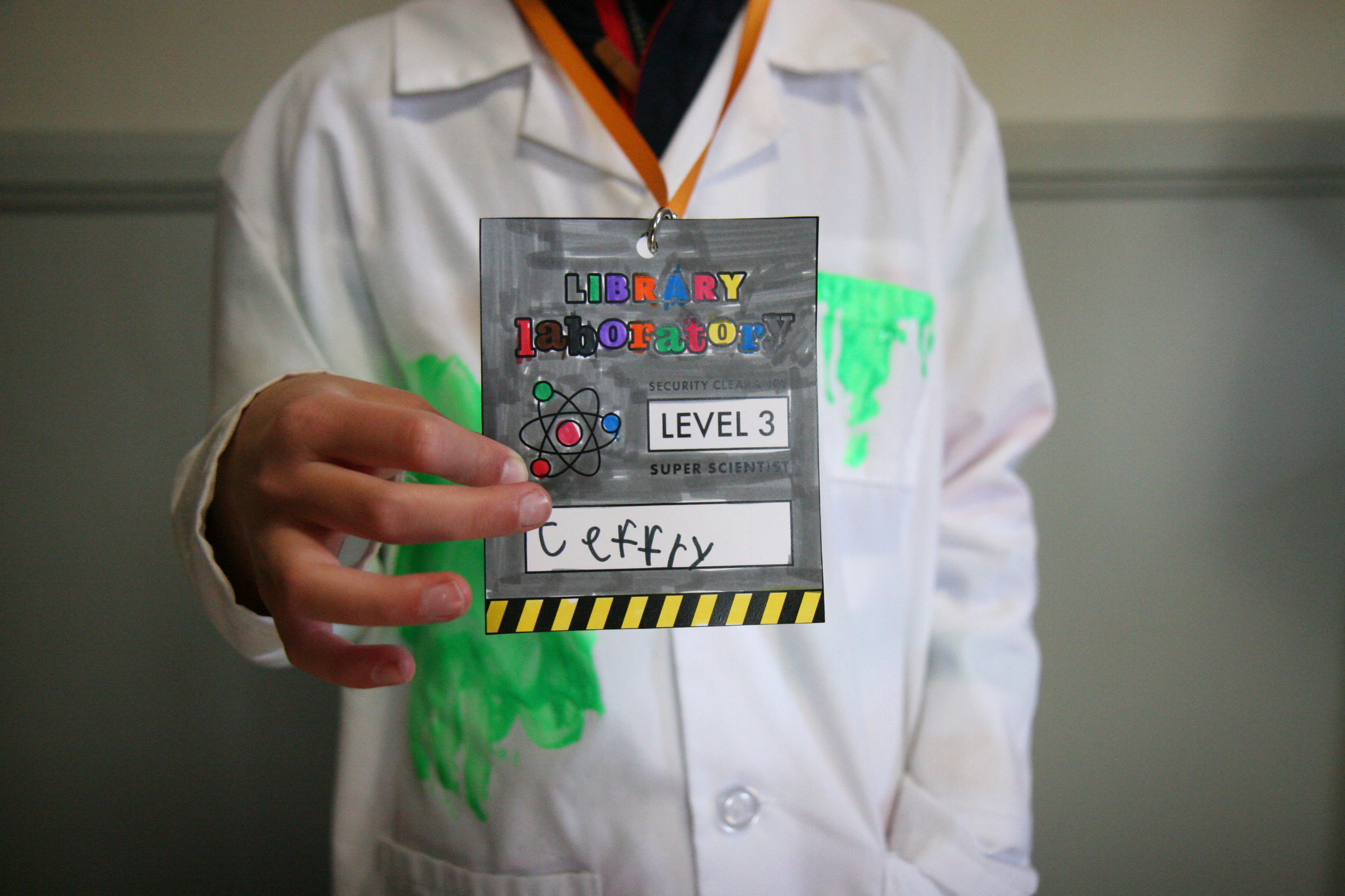 photo of child holding a craft "Library Laboratory" security badge