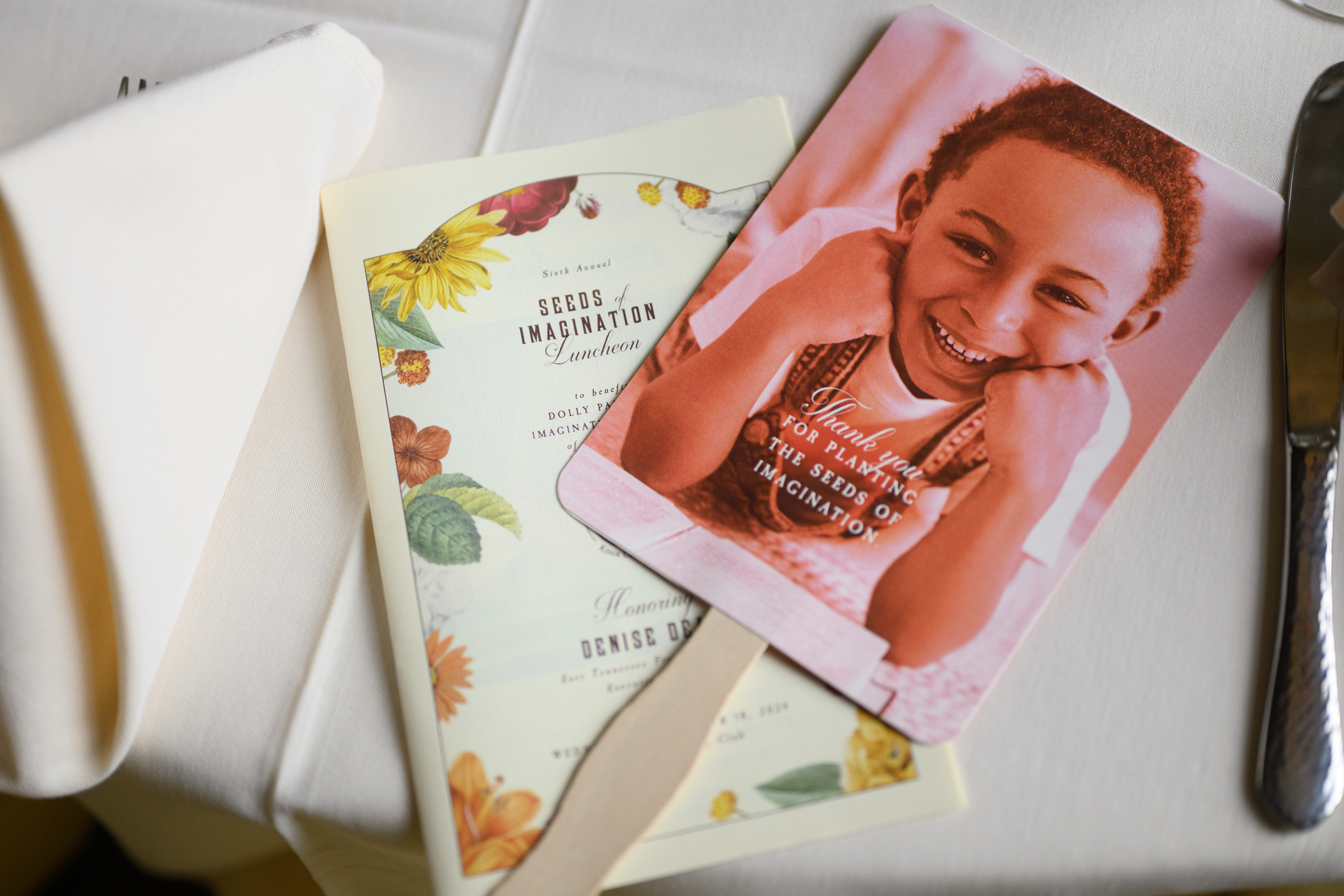A program and a fan from the 2024 Seeds of Imagination Luncheon