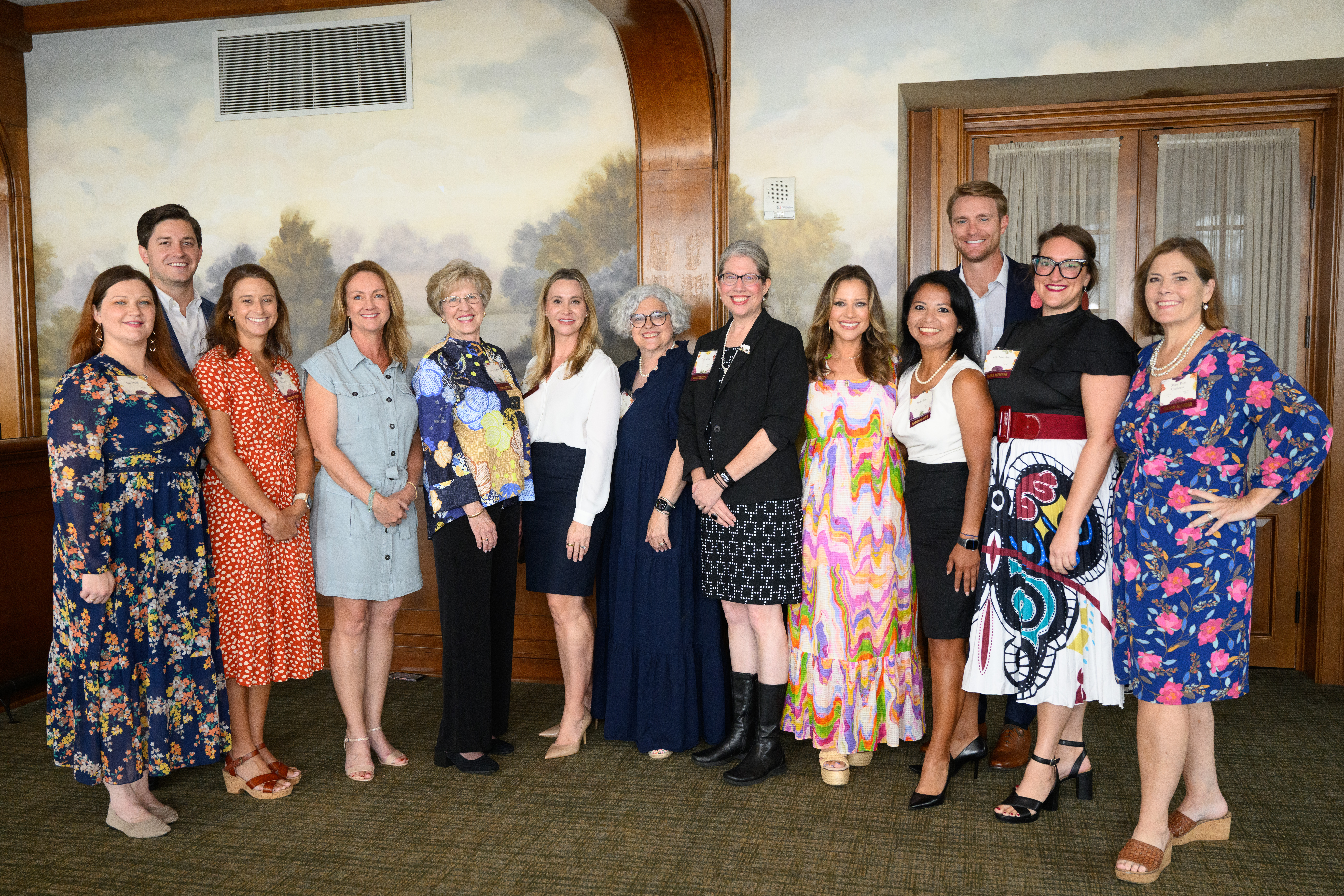 A group of people posed in front of a painted wall