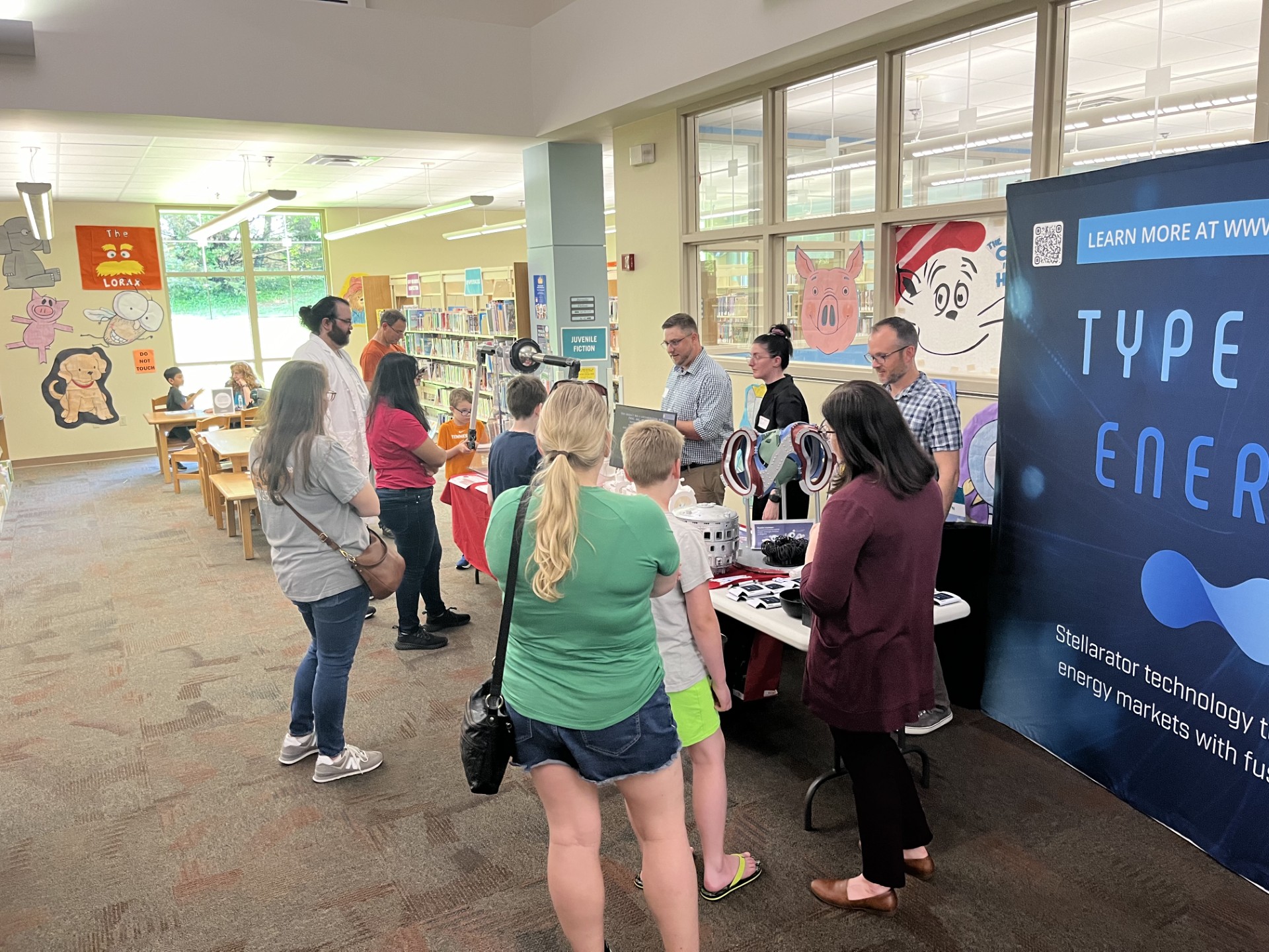 patrons watching a demonstration inside a library