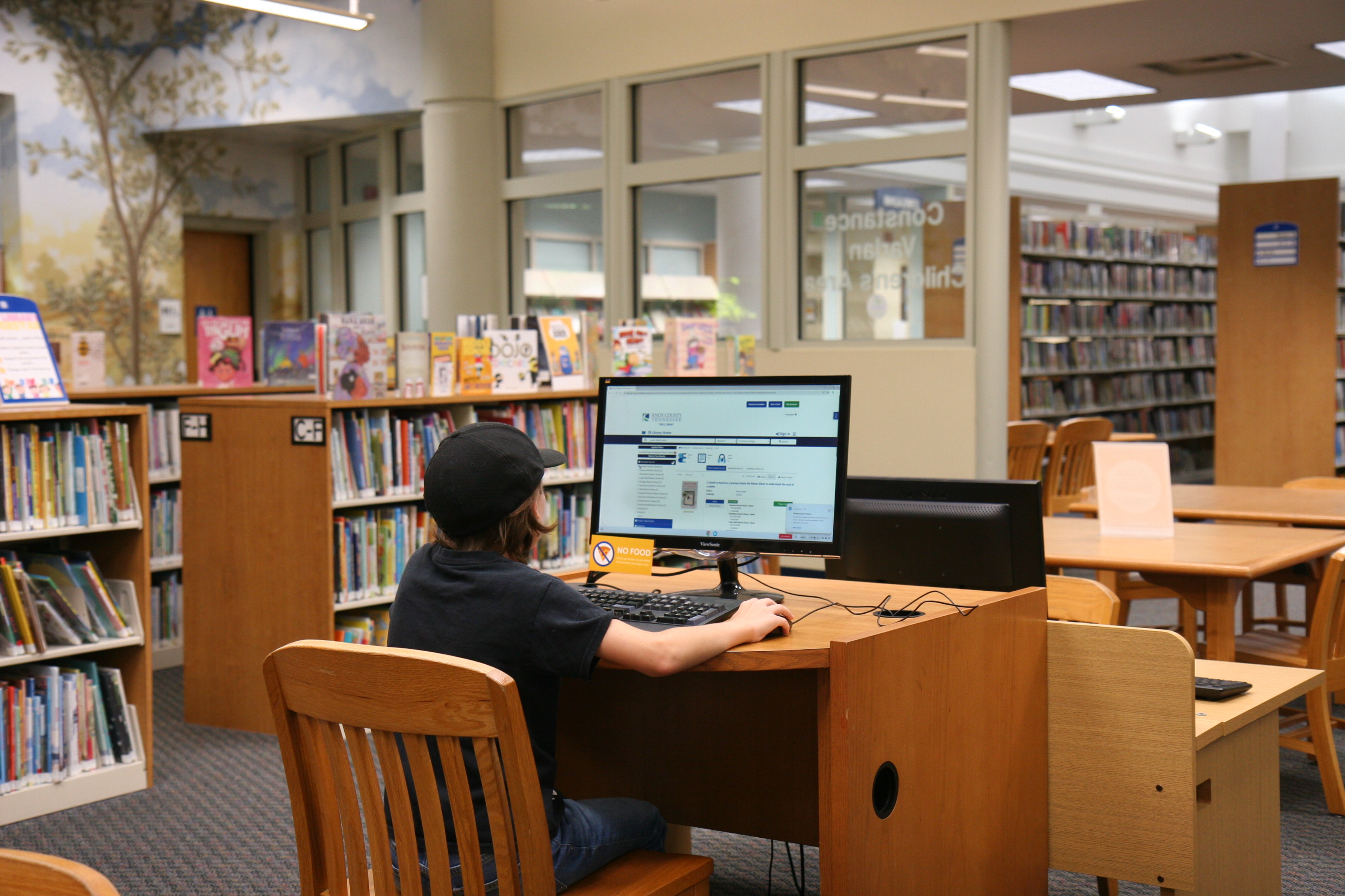 child using computer in a library