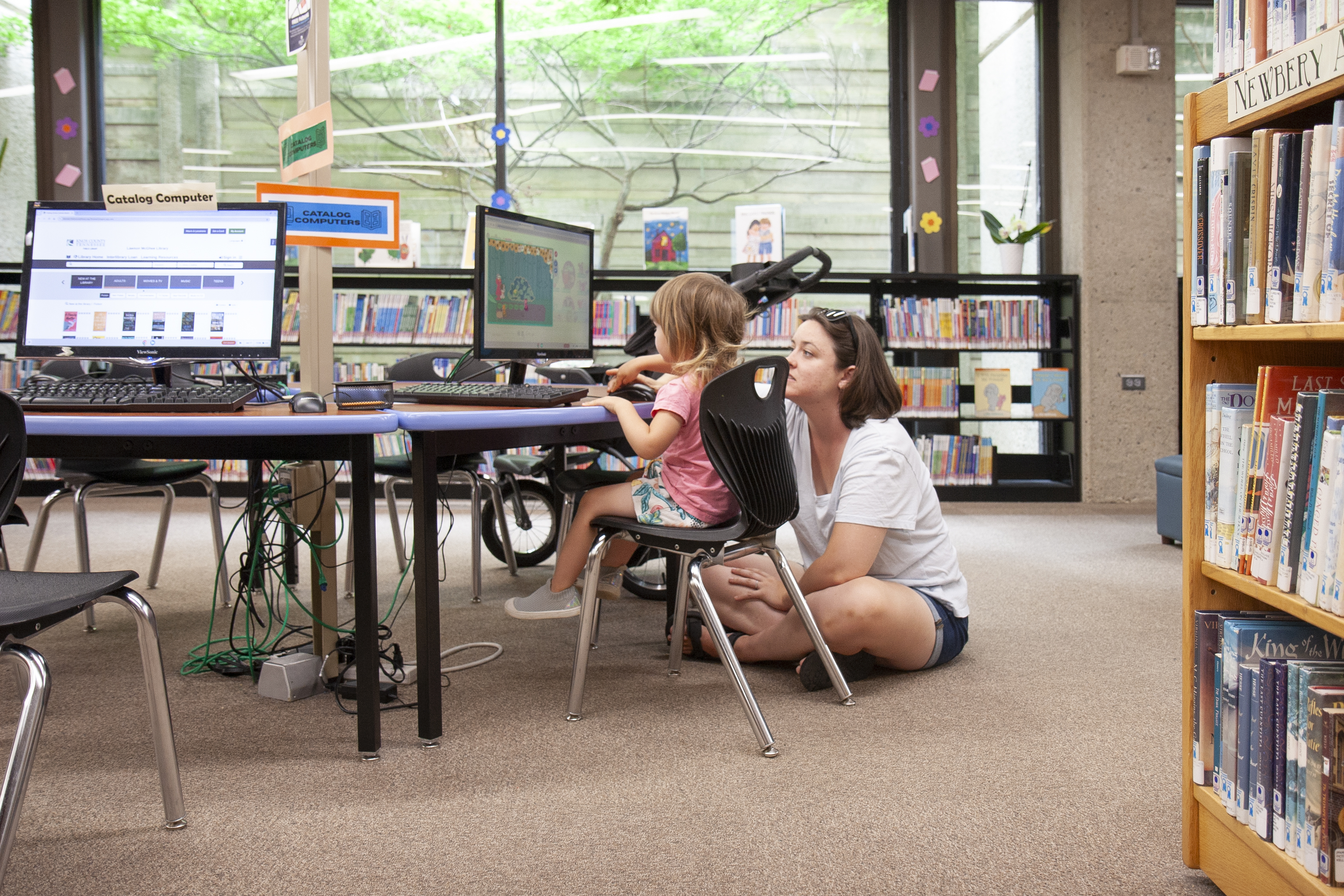mom and child at a computer in a library
