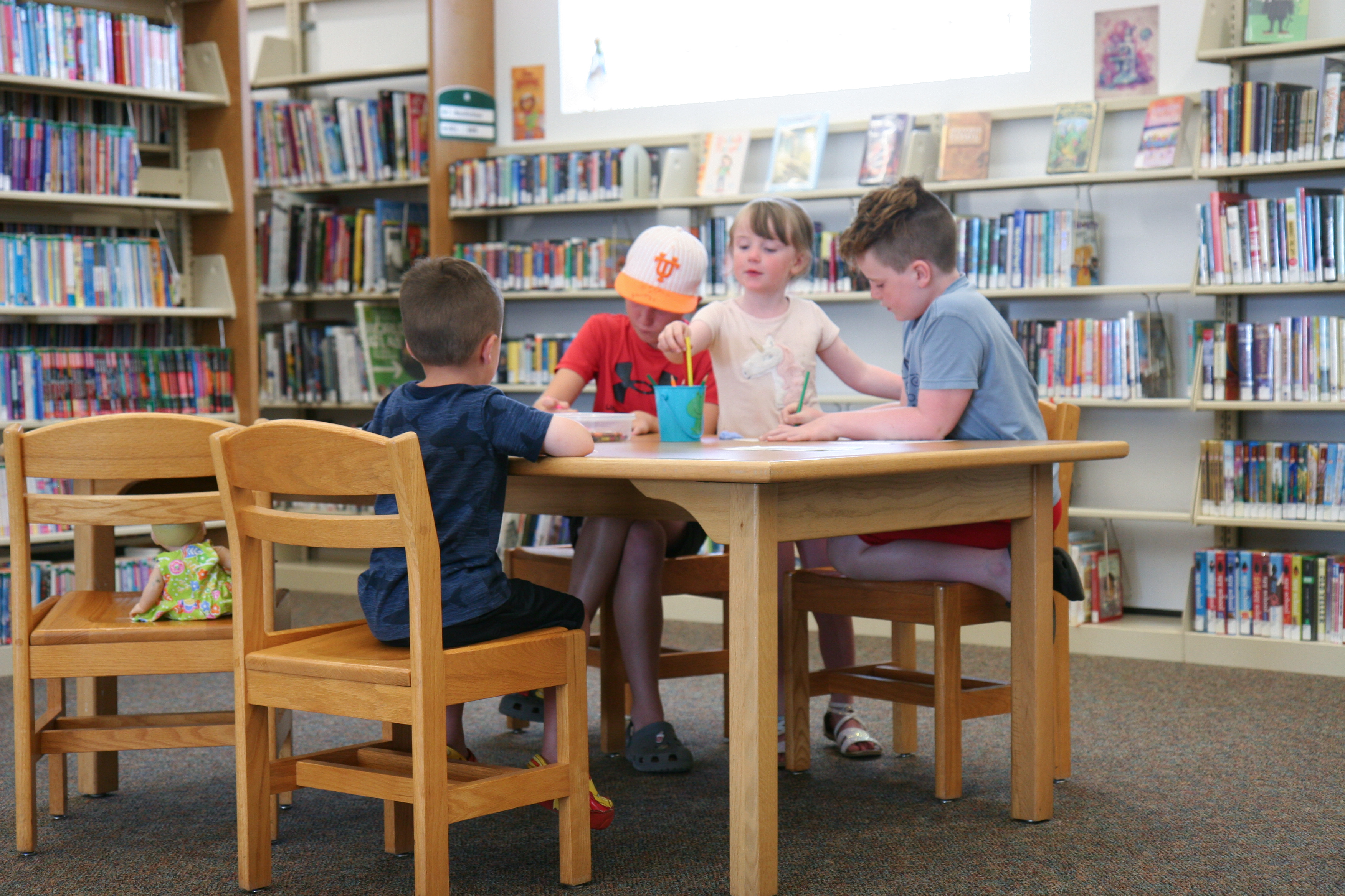 kids working at a table inside a library