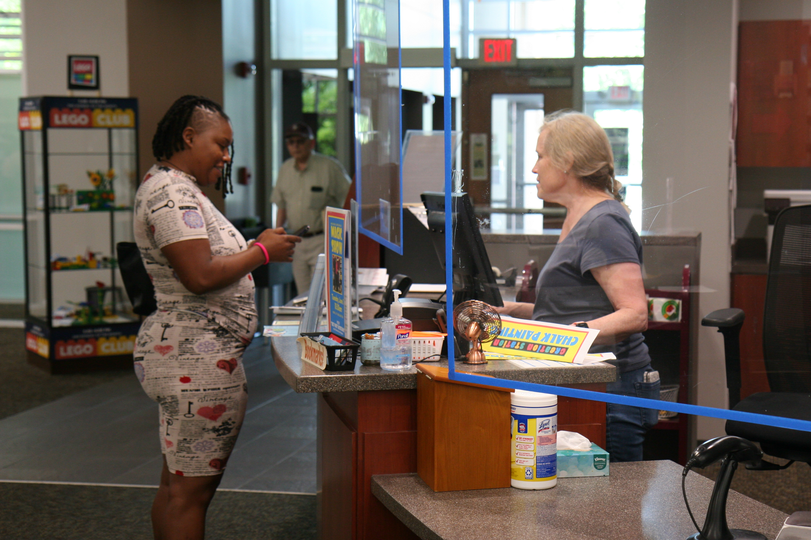 photo of library staff helping a patron at a counter