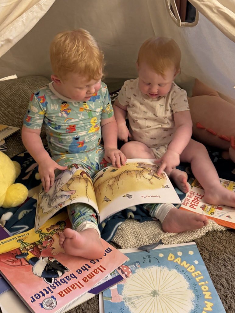 two young kids reading an imagination library book together