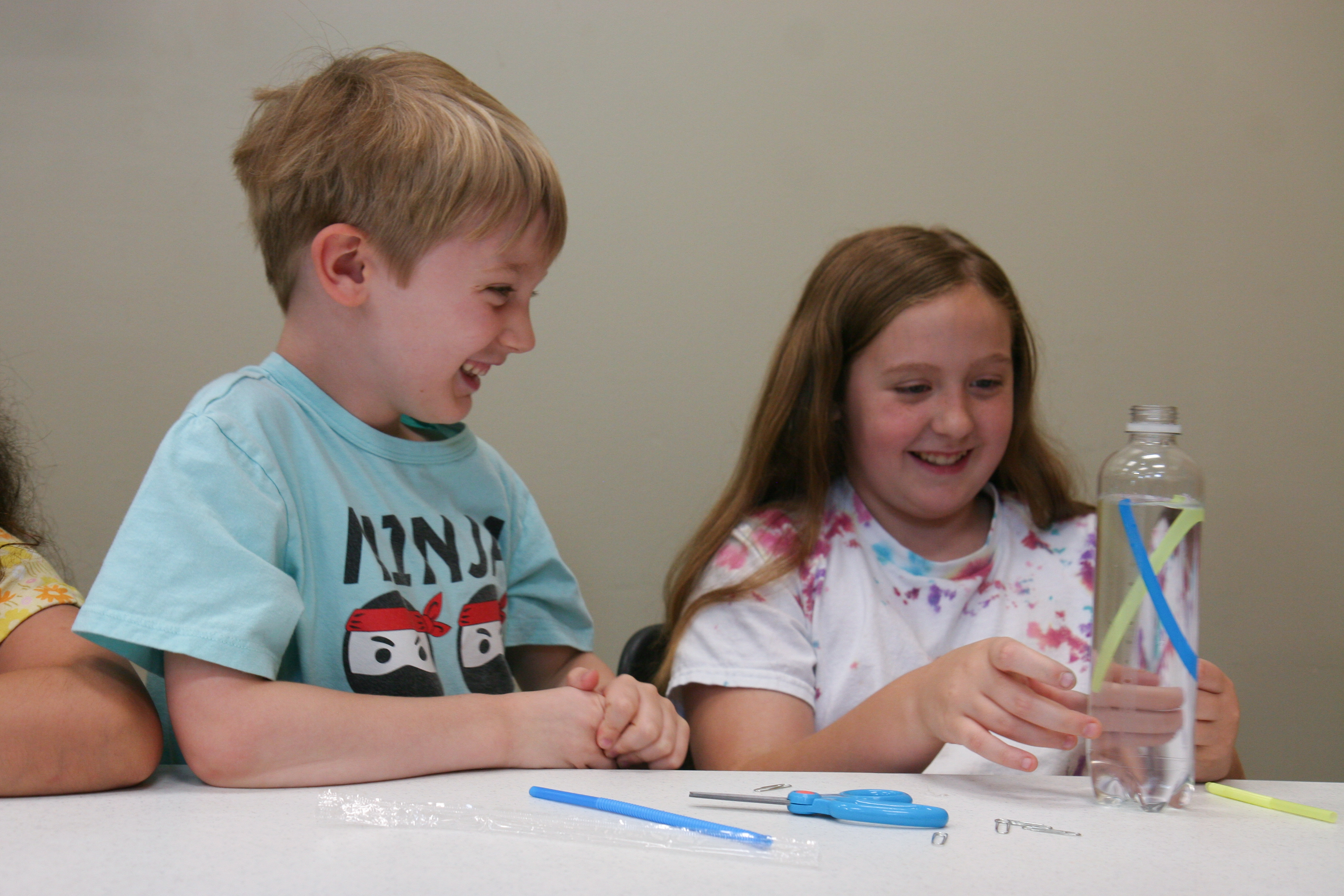 kids working a science experiment with a water bottle