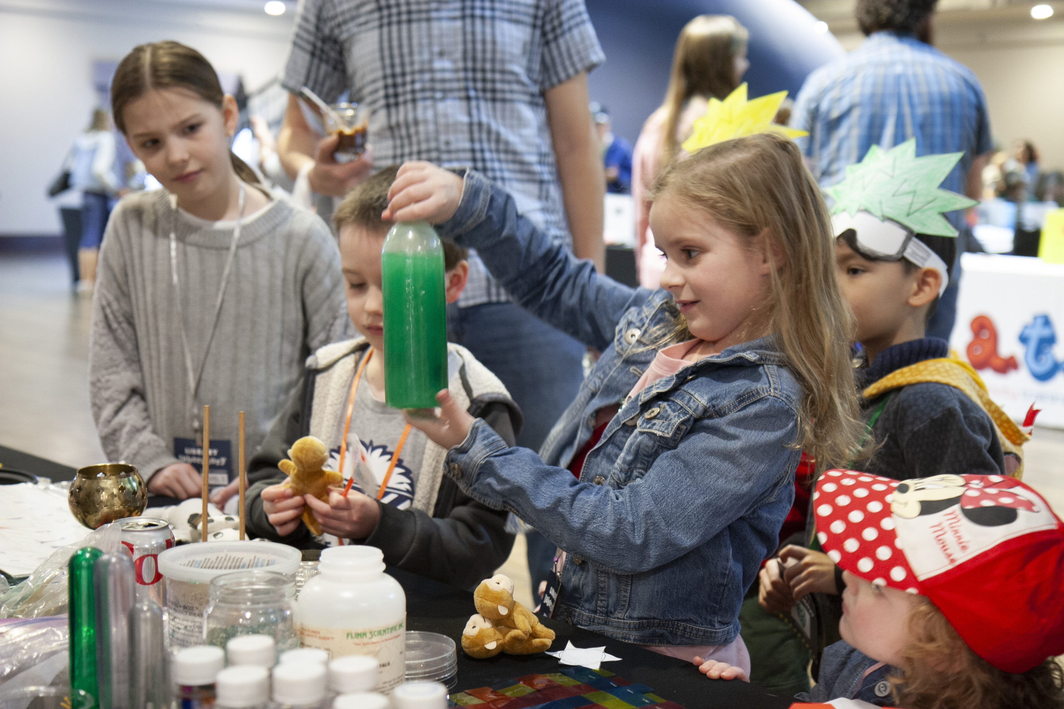 kid examining a green substance in a bottle