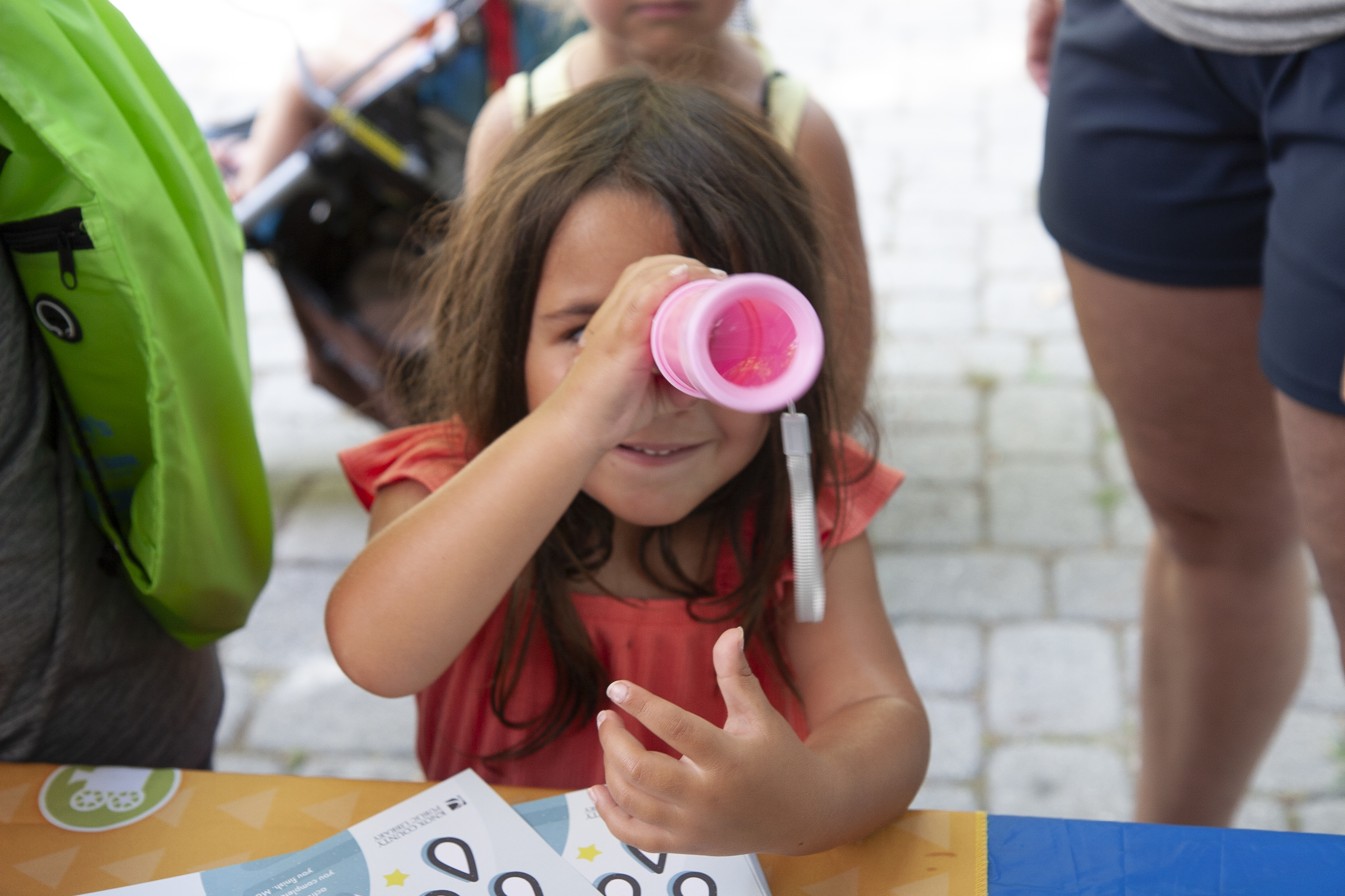 girl looking through a telescope