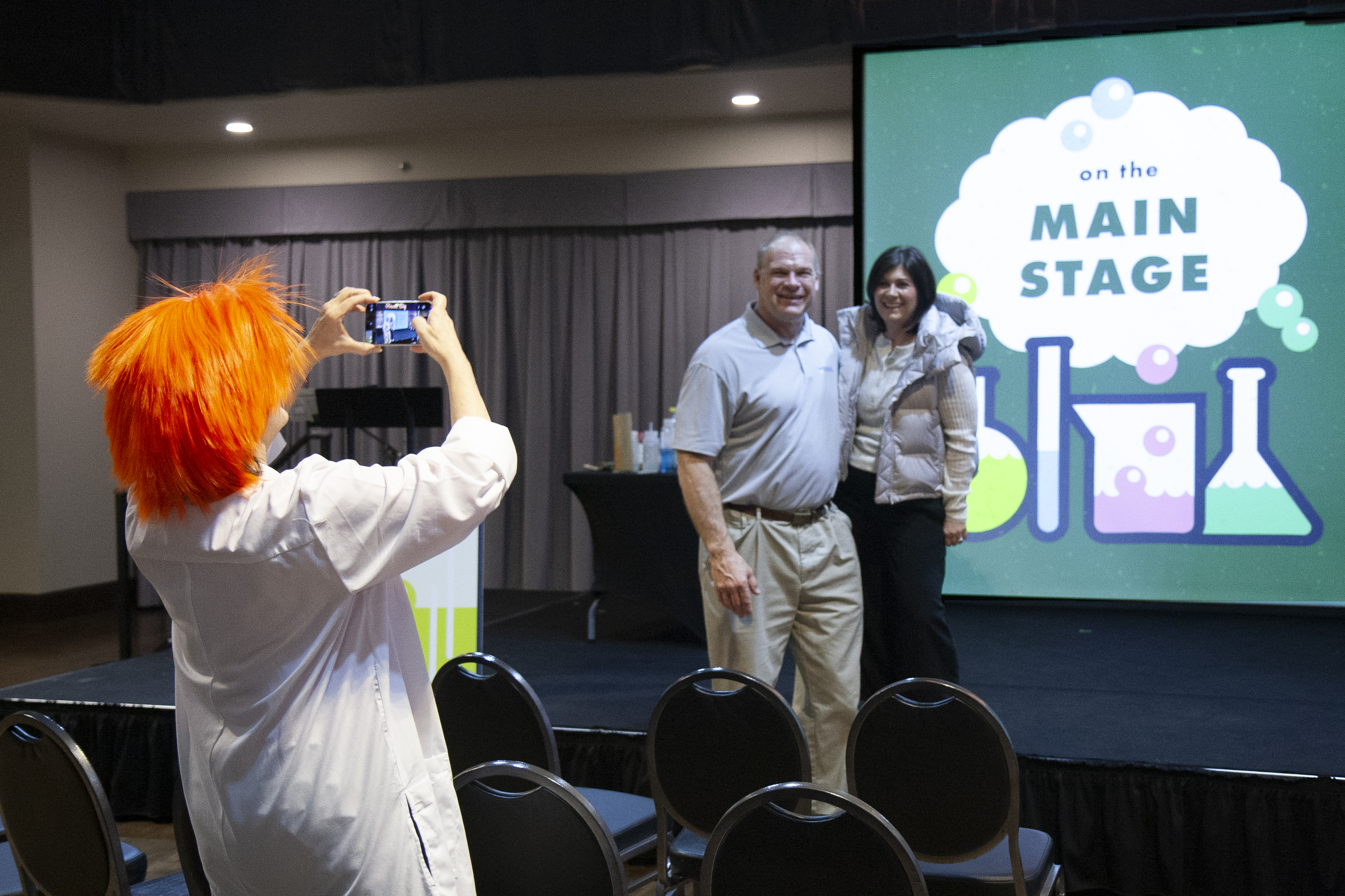 Woman dressed as a scientist taking a photo of Mayor Jacobs