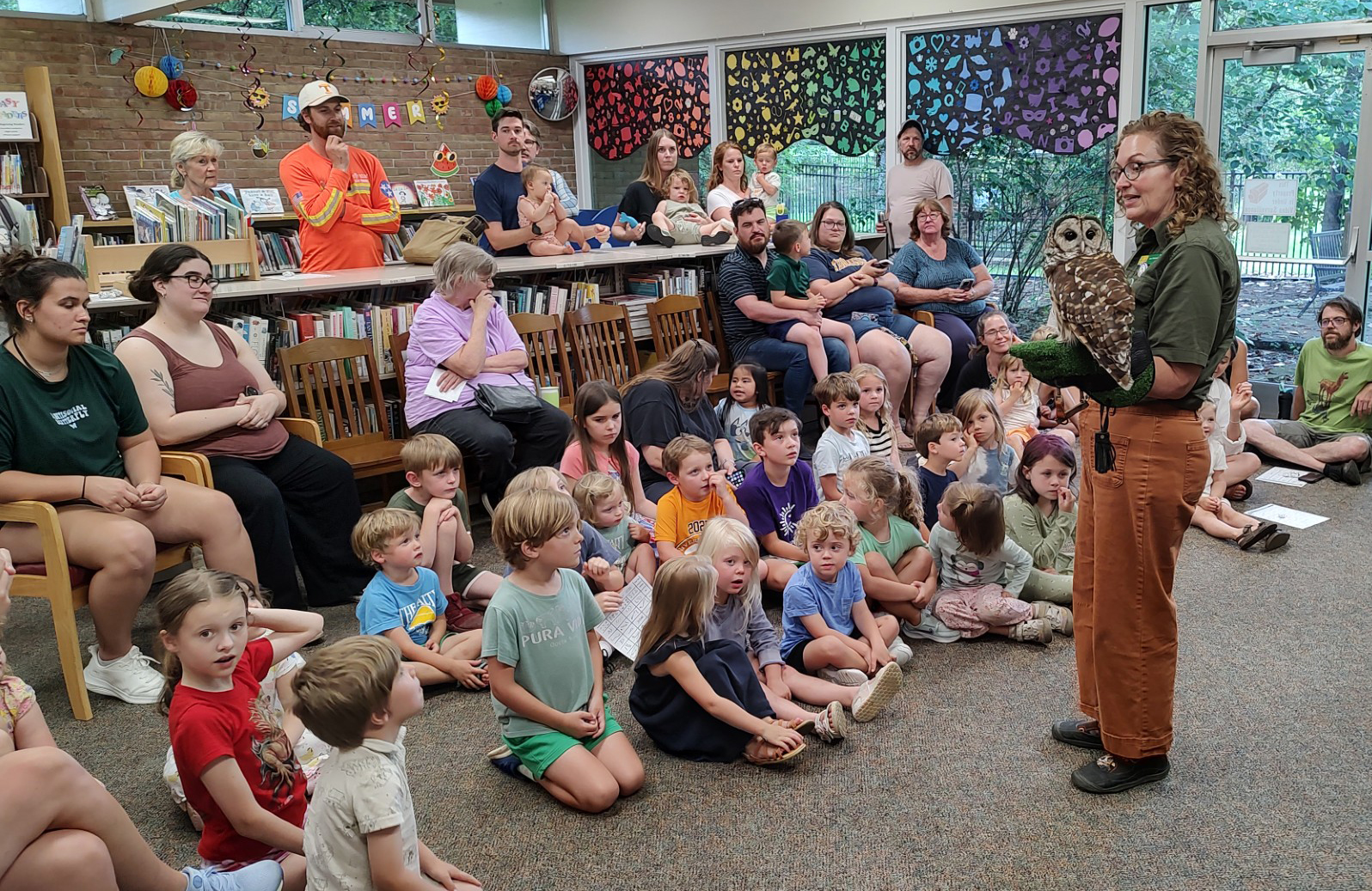 Ranger holding an owl for a group of kids
