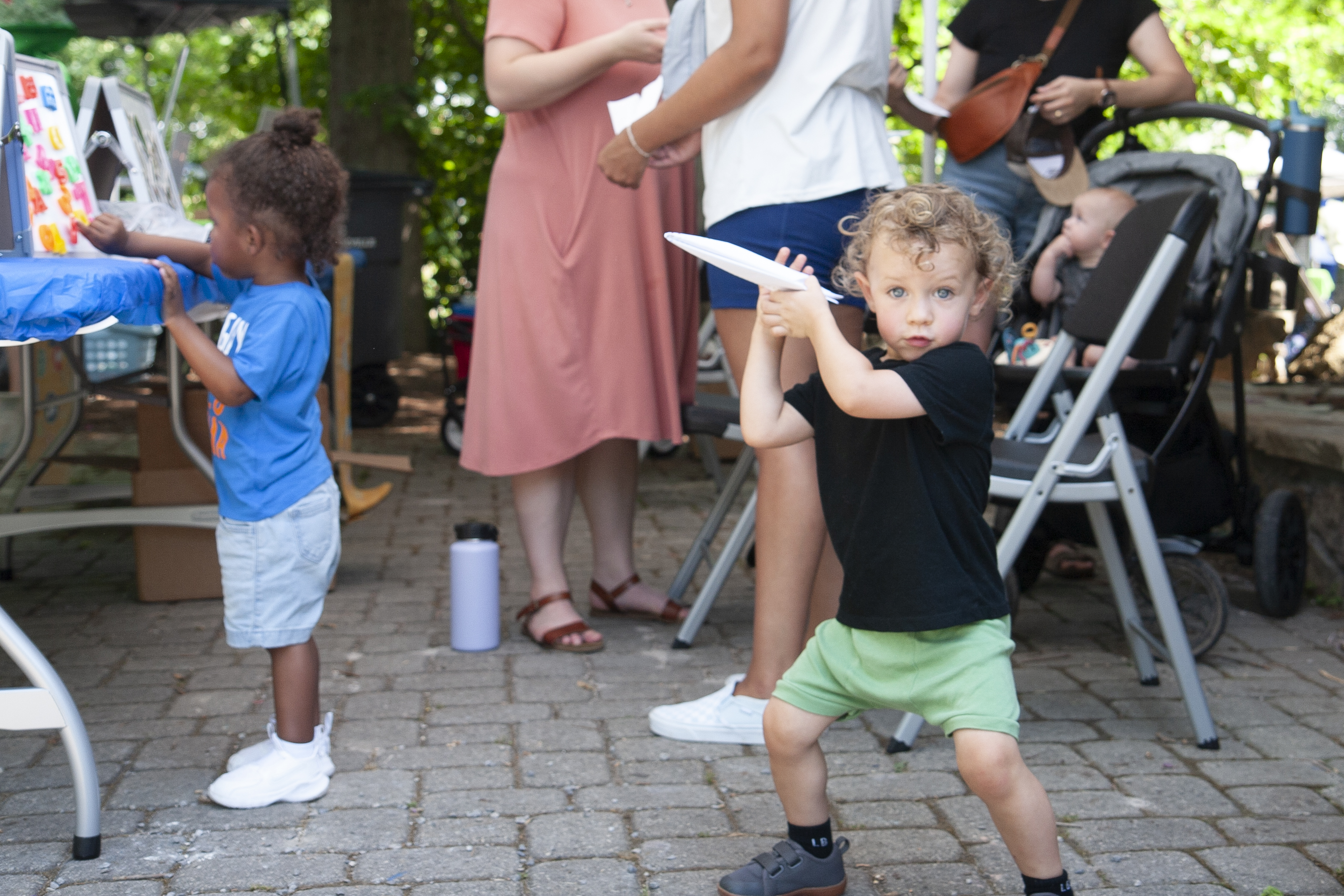 little boy throwing a paper airplane