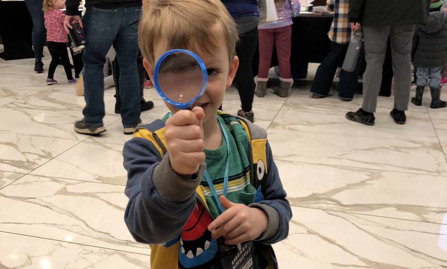 kid holding up a magnifying glass
