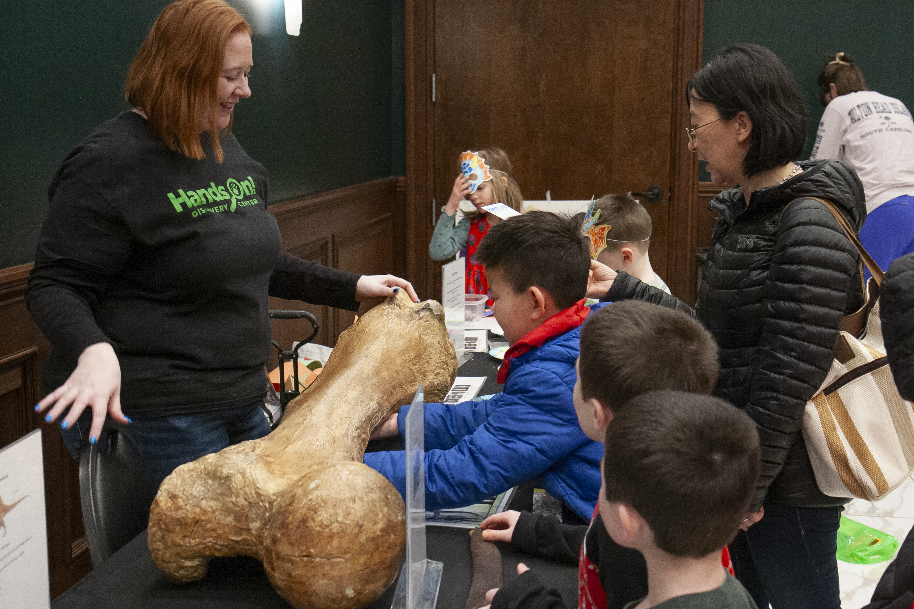 photo of kids examining a large mammoth bone replica