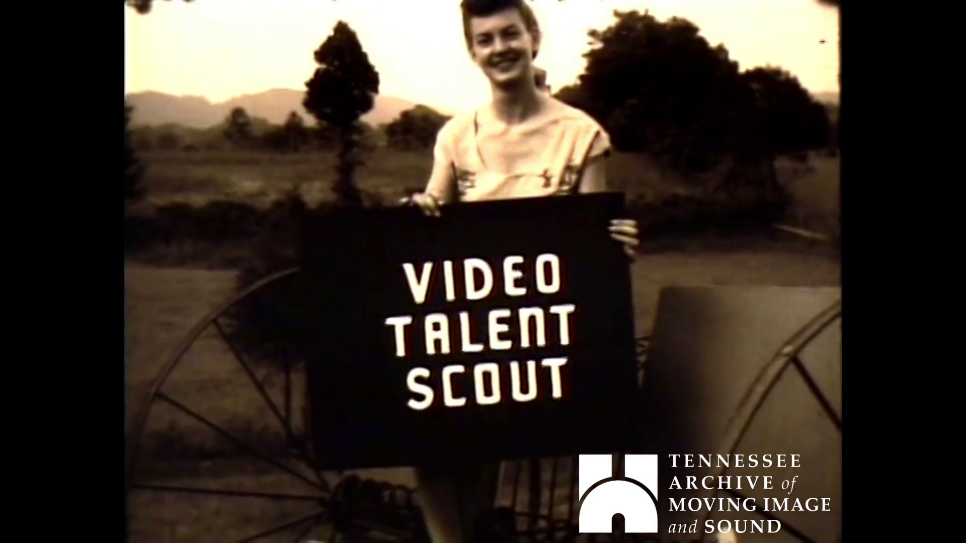 girl holding sign "Video Talent Scout"