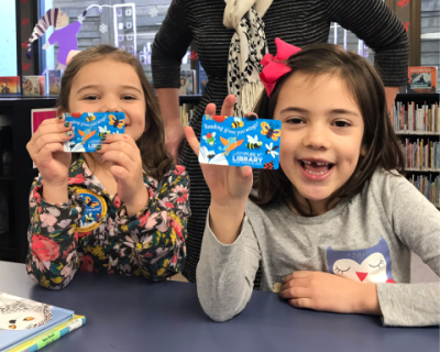 Two girls holding Knox County Public Library cards. 