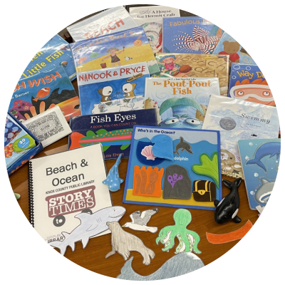 photo of books, ocean animal cutouts, puzzles and other ocean-related manipulatives