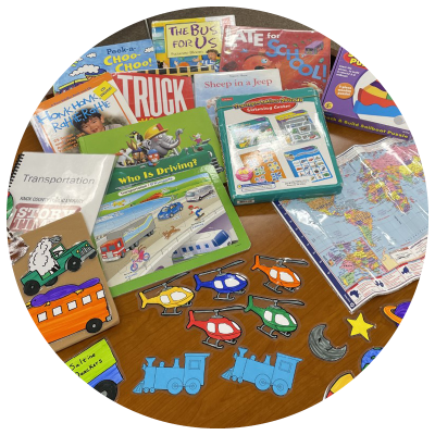 photo of books, games, puzzles, a map, and flannelboard elements