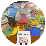 photo of dinosaur books, toys, flannelboard story elements, and puzzle