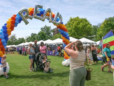 photo of family standing under a balloon arch with the word READ