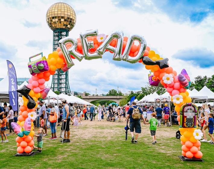 "READ" balloon arch at outdoor Children's Festival with Sunsphere in the background