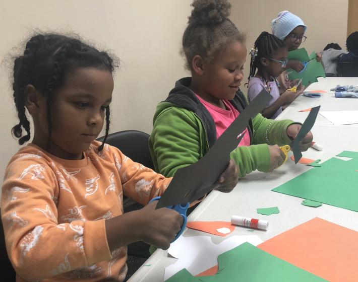 two young girls work on a craft