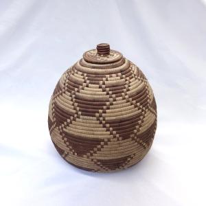 photo of teardrop-shaped basket woven with a geometric pattern in straw and dark brown