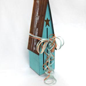photo of tall wooden butterfly house painted aqua, with rusted tin roof